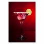 Preview: Ein roter Cocktail im Martini-Glas mit Limette - ein stilvolles Motiv für Cocktail-Liebhaber.