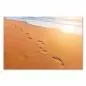 Preview: Fußabdrücke im Sand führen dem Horizont entgegen, wo die Sonne im Meer versinkt. Preview: Fußabdrücke im Sand führen dem Horizont entgegen, wo die Sonne im Meer versinkt.