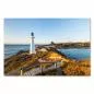 Preview: Ein weißer Leuchtturm auf einer Klippe wird von der aufgehenden Sonne in warmes Licht getaucht. Ein Holzsteg führt zum Leuchtfeuer und bietet einen atemberaubenden Blick. Preview: Ein weißer Leuchtturm auf einer Klippe wird von der aufgehenden Sonne in warmes Licht getaucht. Ein Holzsteg führt zum Leuchtfeuer und bietet einen atemberaubenden Blick.