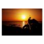 Preview: Freiheit pur: Ein Motorrad am Meer, die Silhouette vor dem Sonnenuntergang vermittelt Abenteuerlust.