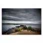Preview: Blick über einen See mit Steinen und Gras im Vordergrund und dunklen Wolken am Himmel. Preview: Blick über einen See mit Steinen und Gras im Vordergrund und dunklen Wolken am Himmel.