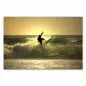 Preview: Silhouette eines Surfers, der eine Welle abreitet, während die untergehende Sonne die Szenerie golden färbt. Preview: Silhouette eines Surfers, der eine Welle abreitet, während die untergehende Sonne die Szenerie golden färbt.