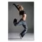 Preview: Blonde Tänzerin in Jeans und bauchfreiem Top springt mit ausgestrecktem Bein und Arm. Preview: Blonde Tänzerin in Jeans und bauchfreiem Top springt mit ausgestrecktem Bein und Arm.