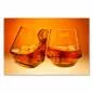 Preview: Zwei Whiskeygläser stoßen an - die orange Beleuchtung erzeugt eine warme Atmosphäre. Preview: Zwei Whiskeygläser stoßen an - die orange Beleuchtung erzeugt eine warme Atmosphäre.