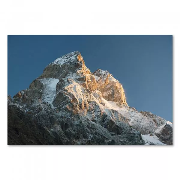 Sonnenstrahlen tauchen schneebedeckten Berggipfel in warmes Licht - malerisch. Sonnenstrahlen tauchen schneebedeckten Berggipfel in warmes Licht - malerisch.