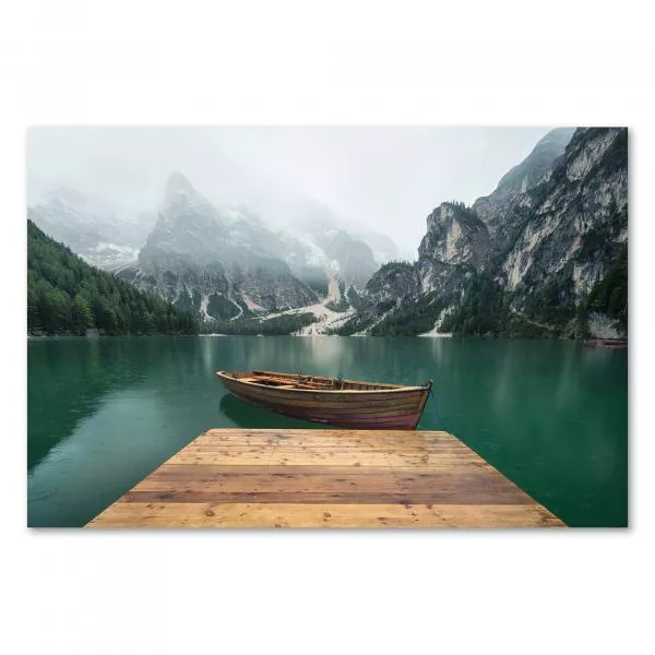 Holzsteg führt auf Bergsee, majestätische Berge im Nebel, einsames Boot. Holzsteg führt auf Bergsee, majestätische Berge im Nebel, einsames Boot.