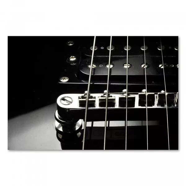 Schwarzweißfotografie der Brücke einer E-Gitarre mit fokussierten Saiten im Vordergrund. Schwarzweißfotografie der Brücke einer E-Gitarre mit fokussierten Saiten im Vordergrund.