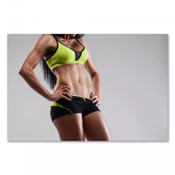 Trainierte Frau in Sportkleidung, grauer Hintergrund, Fokus auf Bauchmuskeln. Trainierte Frau in Sportkleidung, grauer Hintergrund, Fokus auf Bauchmuskeln.