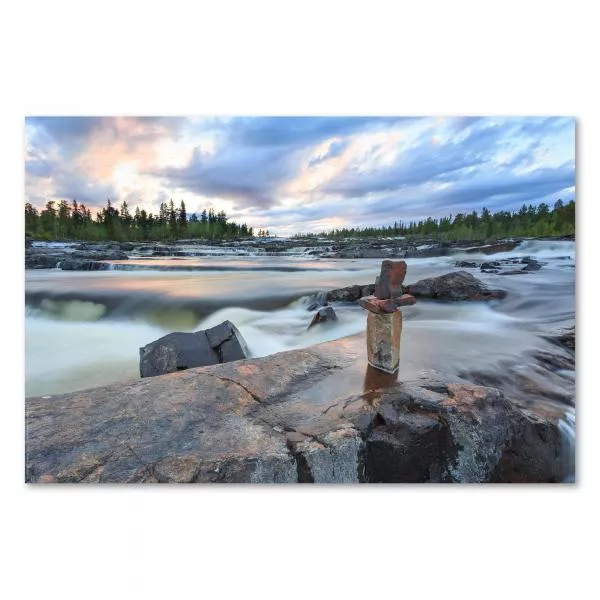 Kunstvoller Steinturm auf Felsen in reißendem Fluss, Abendhimmel leuchtet im Hintergrund. Kunstvoller Steinturm auf Felsen in reißendem Fluss, Abendhimmel leuchtet im Hintergrund.
