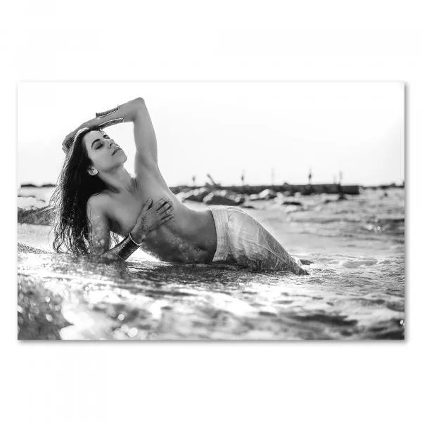 Schwarz-Weiß-Foto: Schöne Frau posiert lasziv am Strand, Meer umspielt Körper. Schwarz-Weiß-Foto: Schöne Frau posiert lasziv am Strand, Meer umspielt Körper.