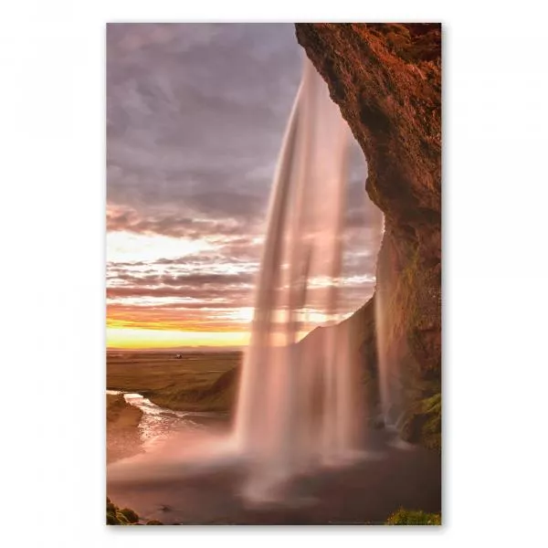 Mächtiger Wasserfall in Island erstrahlt im warmen Licht der untergehenden Sonne. Mächtiger Wasserfall in Island erstrahlt im warmen Licht der untergehenden Sonne.