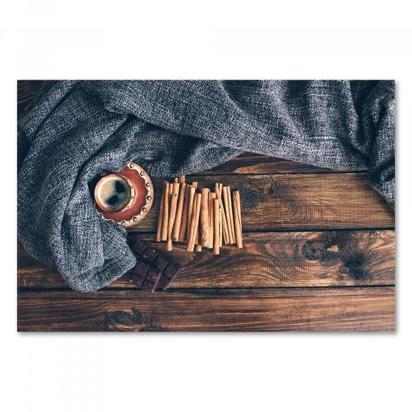 Tasse Kaffee, Zimtstangen und Schokolade auf rustikalem Holztisch, gemütliche Wolldecke im Hintergrund. Tasse Kaffee, Zimtstangen und Schokolade auf rustikalem Holztisch, gemütliche Wolldecke im Hintergrund.