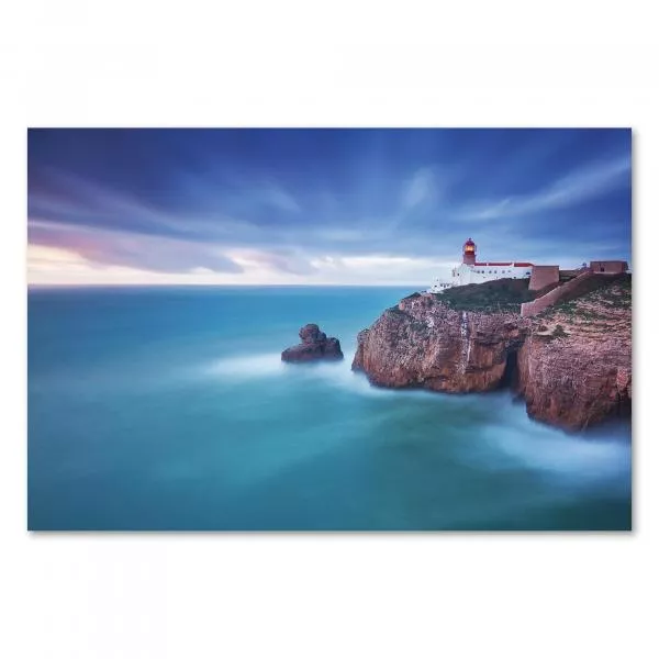 Ein Leuchtturm thront auf einer Klippe über dem tosenden Meer , während der Himmel in Blau- und Lilatönen erstrahlt. Ein Leuchtturm thront auf einer Klippe über dem tosenden Meer , während der Himmel in Blau- und Lilatönen erstrahlt.
