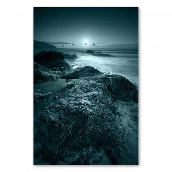 Schroffe Felsen an der Küste werfen mystisches, silbriges Licht über das Meer. Schroffe Felsen an der Küste werfen mystisches, silbriges Licht über das Meer.