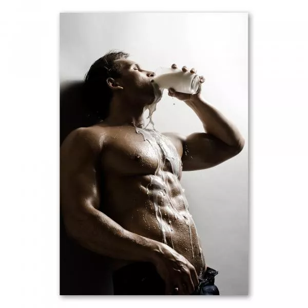 Ein durchtrainierter Mann mit nacktem Oberkörper trinkt genussvoll ein Glas Milch, die ihm über den Körper rinnt. Ein durchtrainierter Mann mit nacktem Oberkörper trinkt genussvoll ein Glas Milch, die ihm über den Körper rinnt.