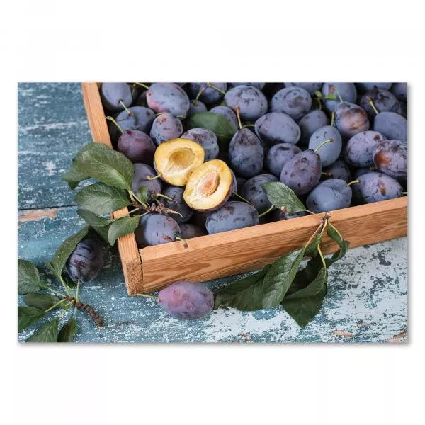 Holzkiste mit reifen, blauen Pflaumen, zwei Hälften zeigen Fruchtfleisch & Kern. Holzkiste mit reifen, blauen Pflaumen, zwei Hälften zeigen Fruchtfleisch & Kern.