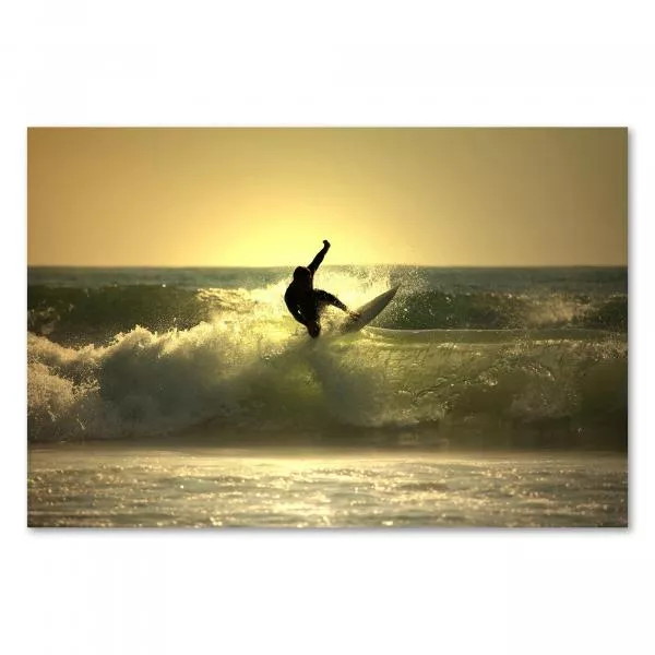 Silhouette eines Surfers, der eine Welle abreitet, während die untergehende Sonne die Szenerie golden färbt. Silhouette eines Surfers, der eine Welle abreitet, während die untergehende Sonne die Szenerie golden färbt.