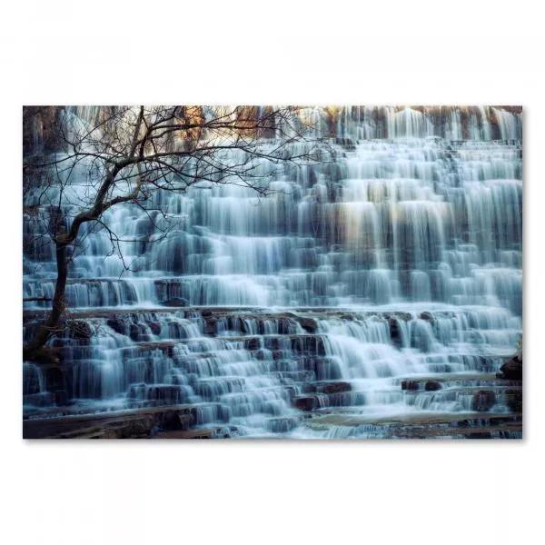 Mächtiger Wasserfall stürzt über Stufen, kahler Baum am Rand, unterstreicht Kraft der Natur. Mächtiger Wasserfall stürzt über Stufen, kahler Baum am Rand, unterstreicht Kraft der Natur.
