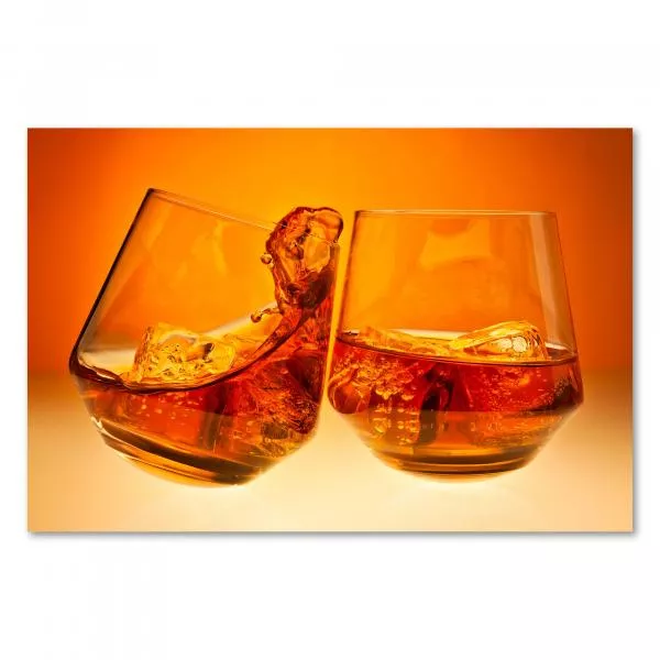 Zwei Whiskeygläser stoßen an - die orange Beleuchtung erzeugt eine warme Atmosphäre. Zwei Whiskeygläser stoßen an - die orange Beleuchtung erzeugt eine warme Atmosphäre.