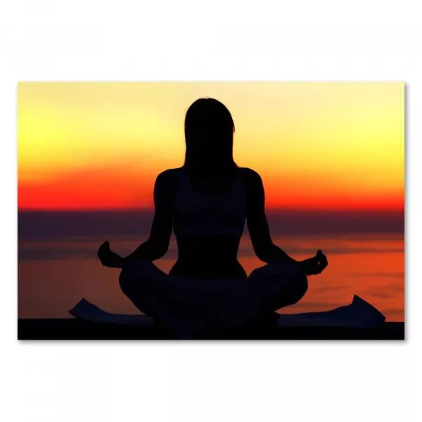 Eine Frau meditiert auf einer Yogamatte im Sonnenuntergang - ein Bild von Ruhe und Entspannung. Eine Frau meditiert auf einer Yogamatte im Sonnenuntergang - ein Bild von Ruhe und Entspannung.