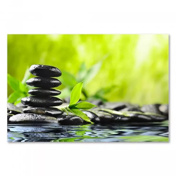 Schwarze Zen-Steine spiegeln sich im Wasser, grüner Bambus und verschwommener Hintergrund strahlen Ruhe aus. Schwarze Zen-Steine spiegeln sich im Wasser, grüner Bambus und verschwommener Hintergrund strahlen Ruhe aus.