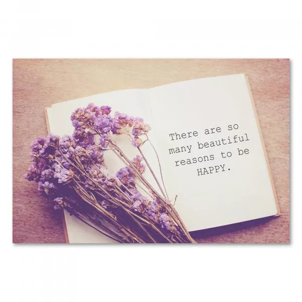 Offenes Notizbuch mit dem Zitat "There are so many beautiful reasons to be happy." und einem Strauß lila Trockenblumen. Offenes Notizbuch mit dem Zitat "There are so many beautiful reasons to be happy." und einem Strauß lila Trockenblumen.
